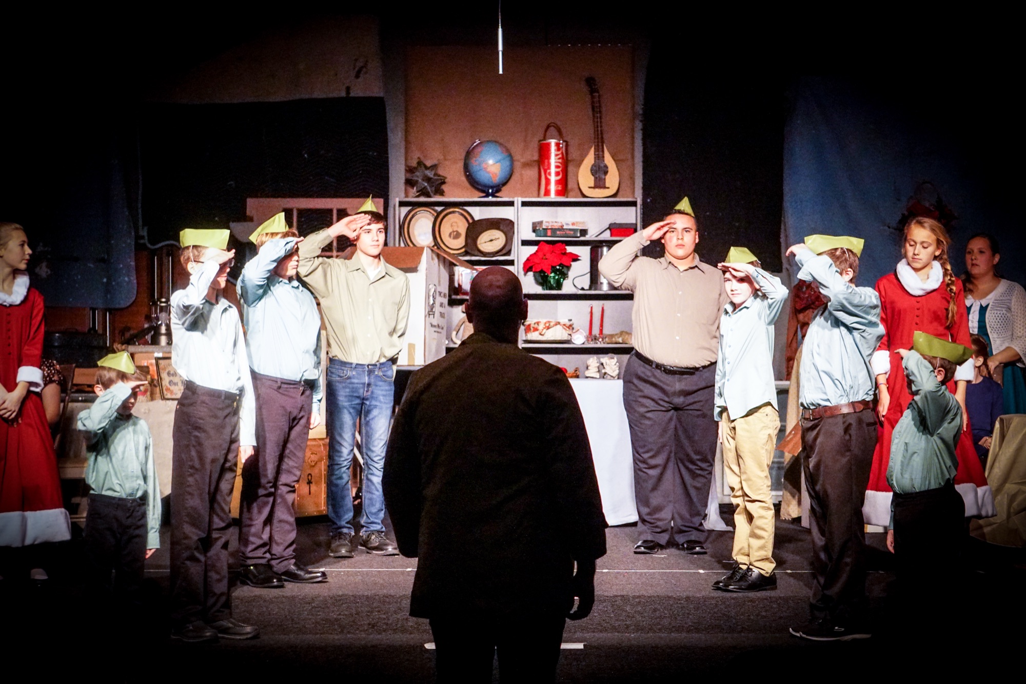 The full cast mid-scene during a stage production